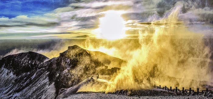 Golden mist rising over mountain peaks at sunrise